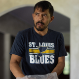 Man wearing a St. Louis Blues t-shirt holding a plastic bag.